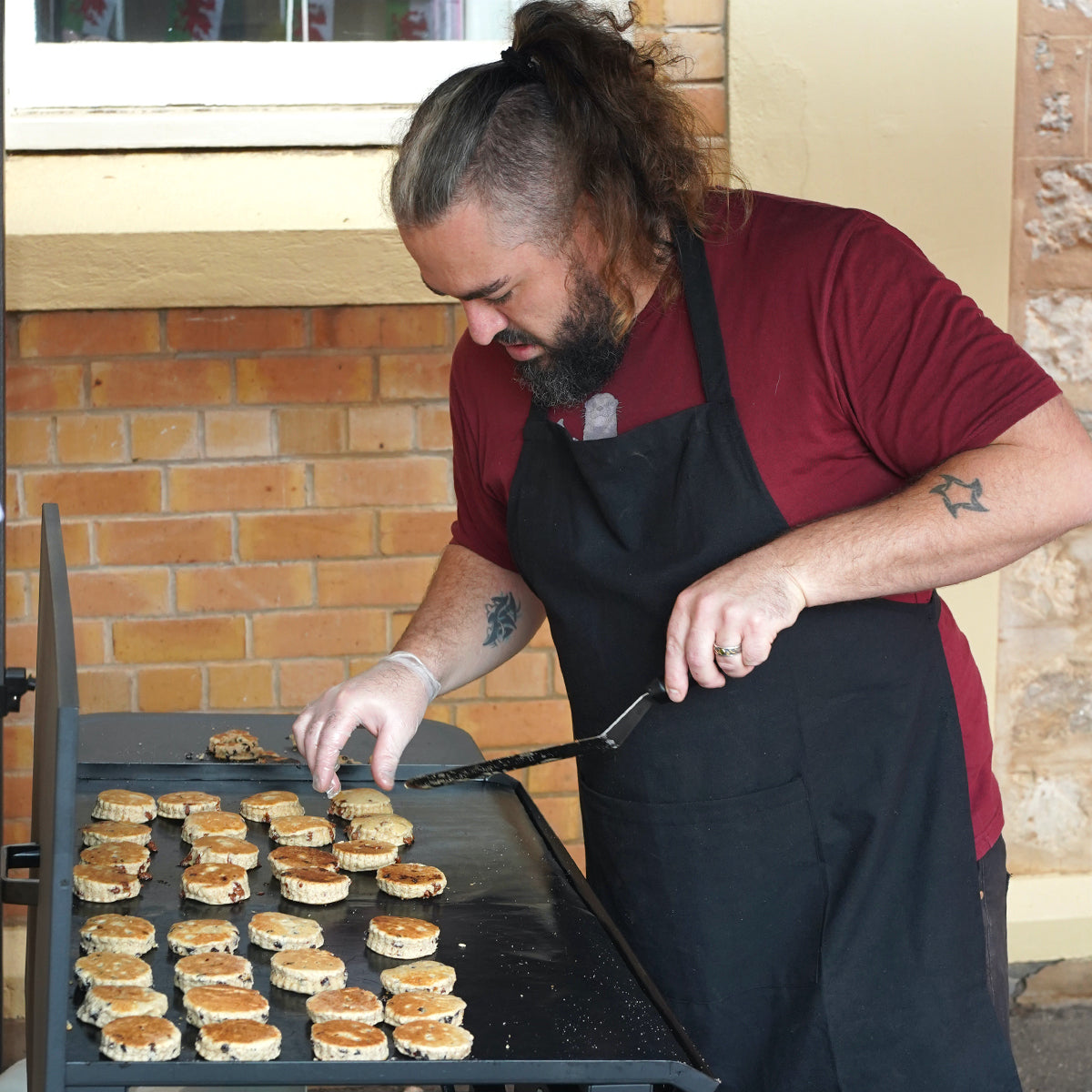 Tom Harper, Dragonstone Bakes founder, cooking traditional Welsh Cakes on a flat top BBQ