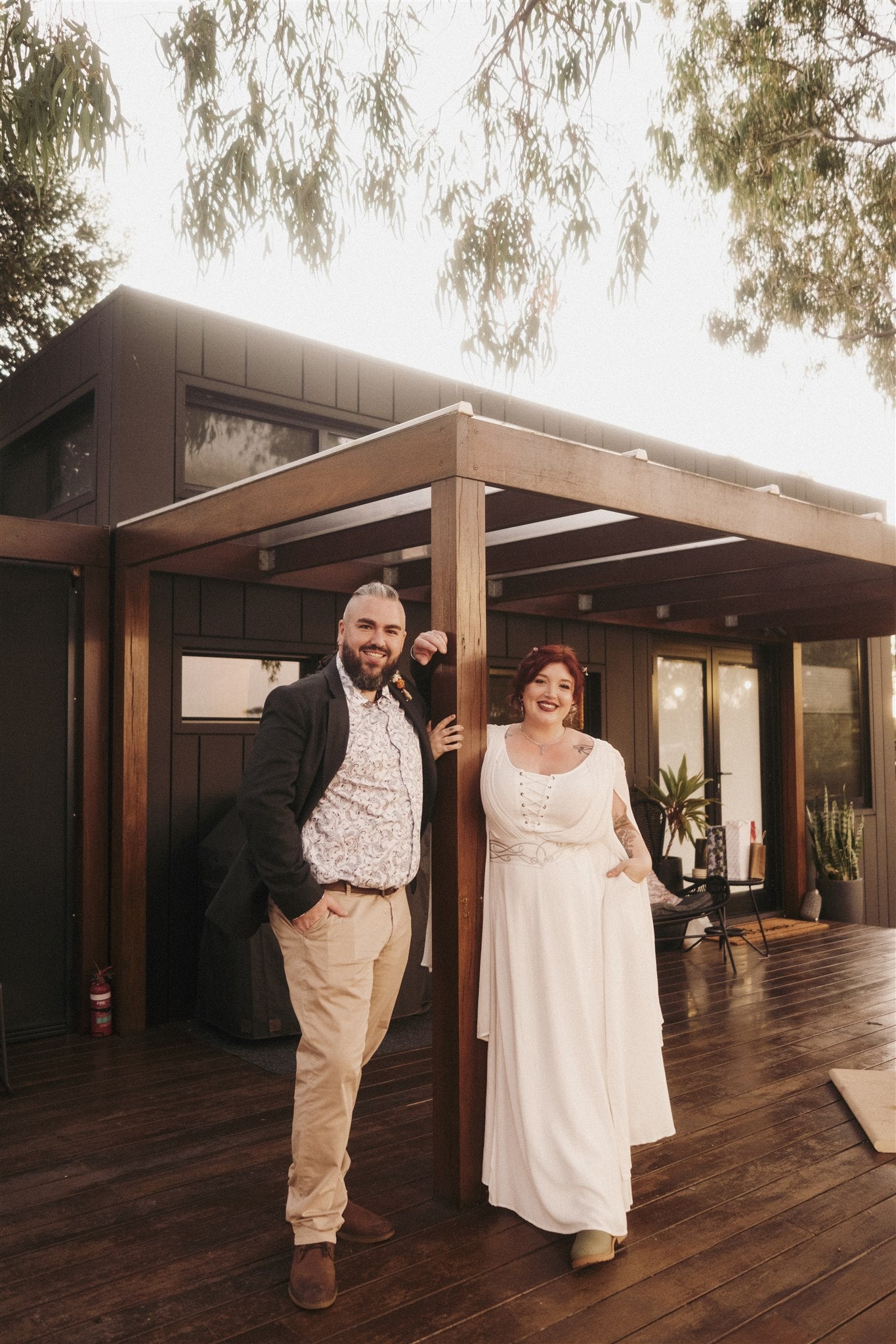 Dragonstone Bakes founder and his wife standing in front of a tiny home on their wedding day.